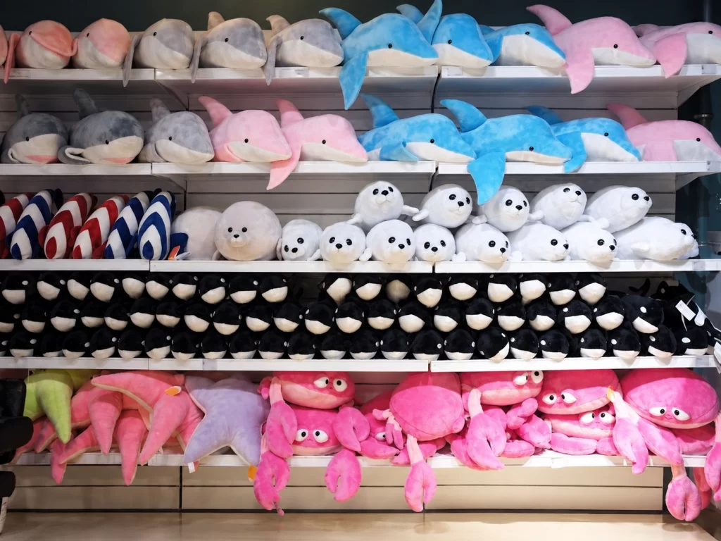 Small branded-style character plush presented beside retail merchandise as a qualifying purchase gift